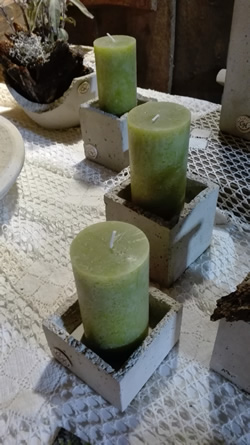 Kerzenhalter aus Beton mit grünen Kerzen